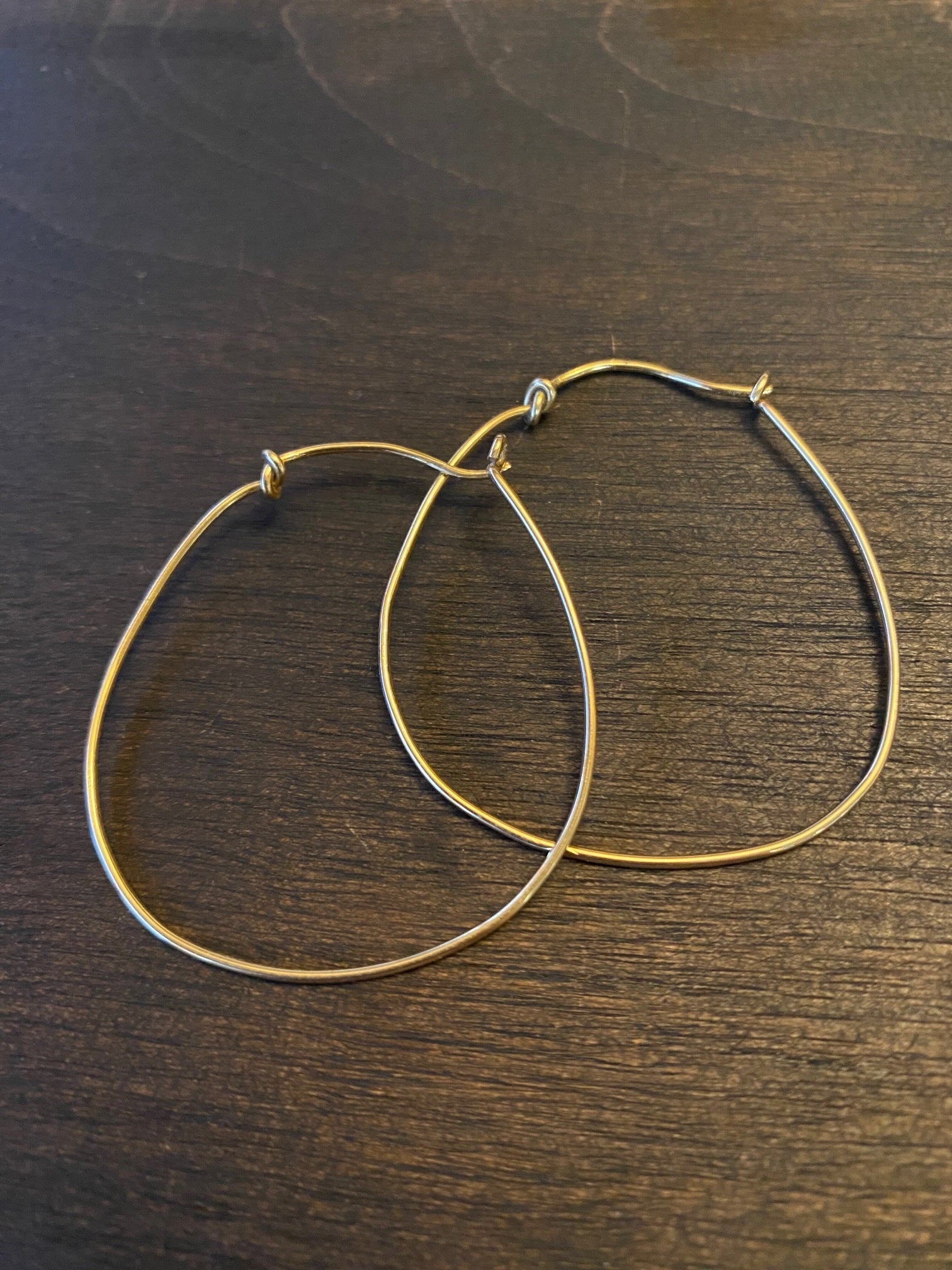 Gold horseshoe hoop earrings by Chorthip, featuring a shiny gold finish and classic horseshoe shape, displayed on a white background.