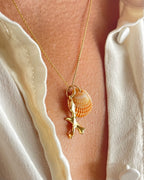 Gold coral pendant with shell accent from Chorthip, showcasing a detailed and elegant jewelry piece on a neutral background.