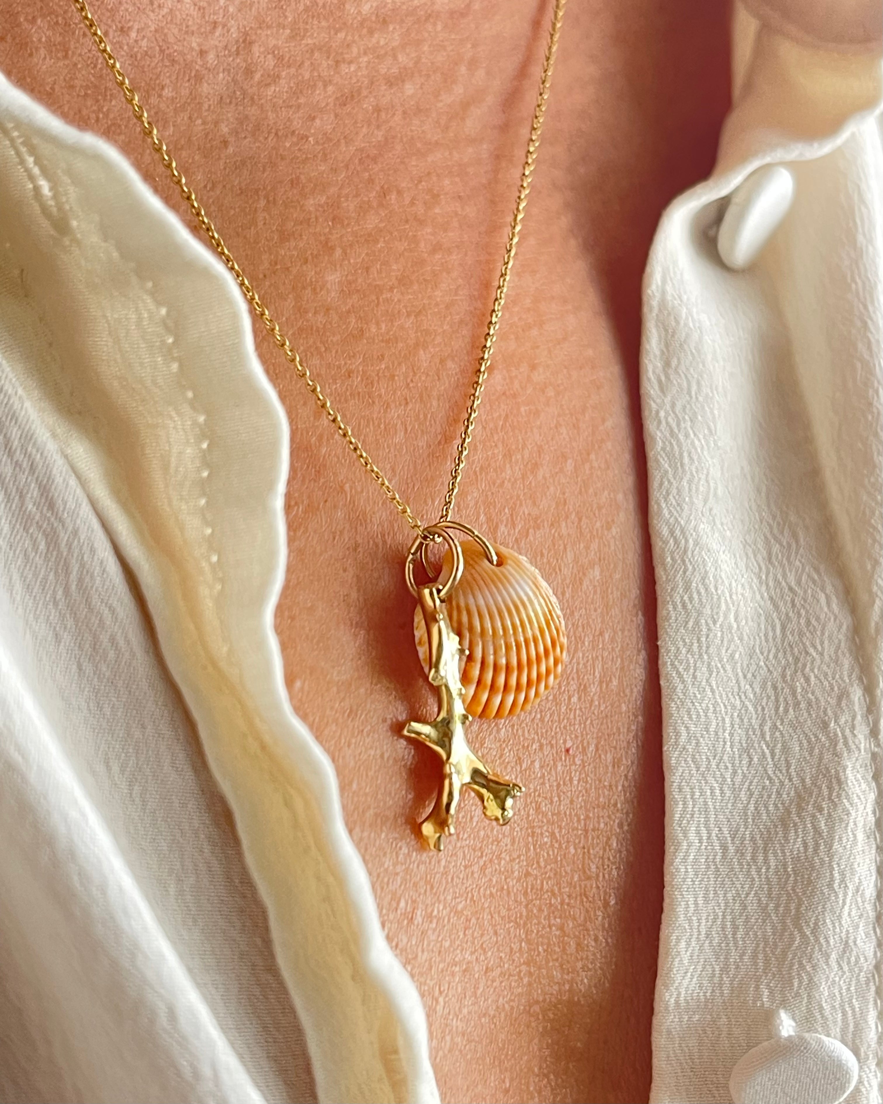 Gold coral pendant with shell accent from Chorthip, showcasing a detailed and elegant jewelry piece on a neutral background.