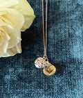 Silver sand dollar pendant by Chorthip featuring a teardrop citrine stone, showing detailed sand dollar design and polished finish.