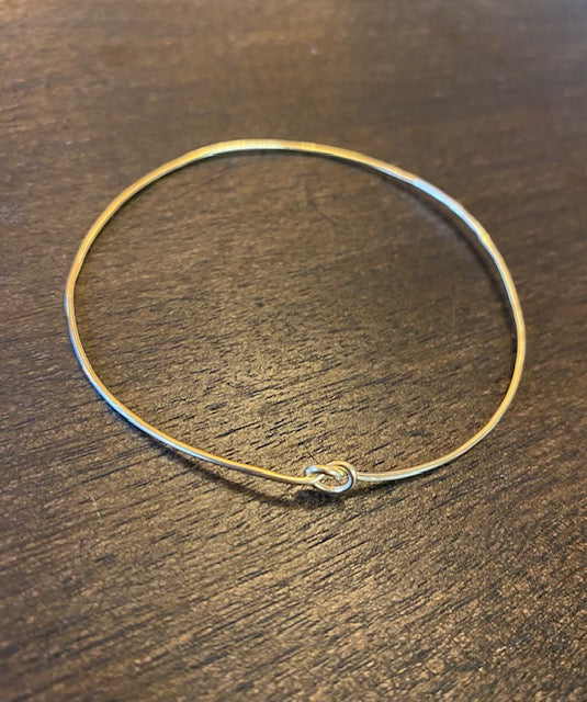 Chorthip Single Knot Bangle, elegant silver jewelry piece with a sleek, minimalist design, showcasing the smooth, polished surface.