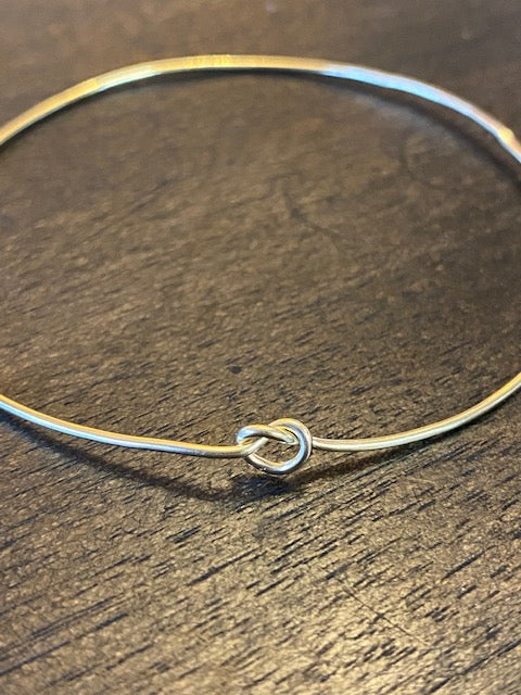 Chorthip single knot bangle bracelet with a sleek, minimalist design, showcasing a smooth, polished metal finish.