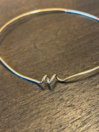 Chorthip Helix Spiral Bangle earrings featuring sleek, twisted metal design with a polished finish on a white background.