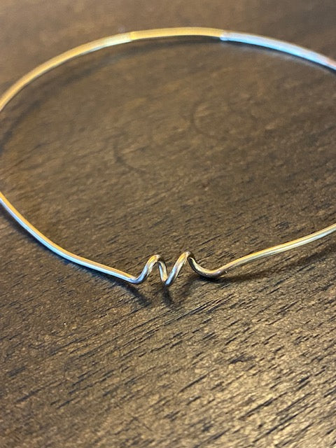 Chorthip Helix Spiral Bangle earrings featuring sleek, twisted metal design with a polished finish on a white background.