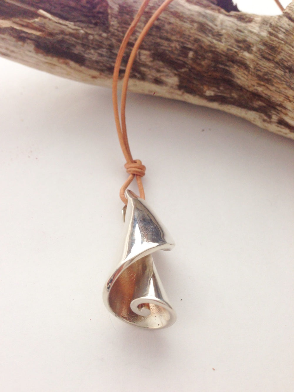 Silver spiral shell pendant by Chorthip, featuring a detailed, polished design perfect for necklace jewelry.