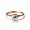 Chorthip Arisa Simplicity Engagement Ring featuring a sleek band and a central gemstone on a neutral background.