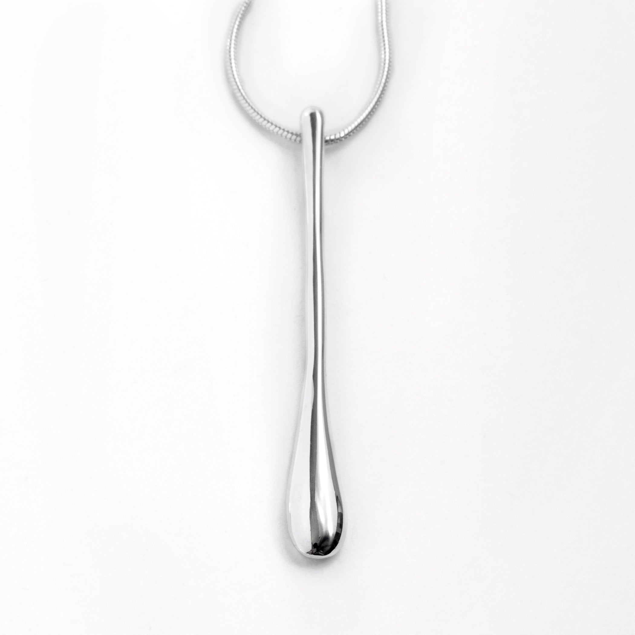 Chorthip Raindrop Pendant hanging on a chain, close-up view showing its sleek, shiny teardrop-shaped design and polished surface.