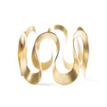 Gold infinity bangle by Chorthip featuring a sleek, open design with smooth curves and polished finish.