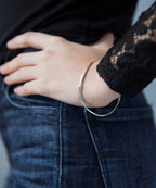 Chorthip Raindrop Bangle featuring a sleek, silver design with a textured raindrop pattern on a stylish bangle bracelet.