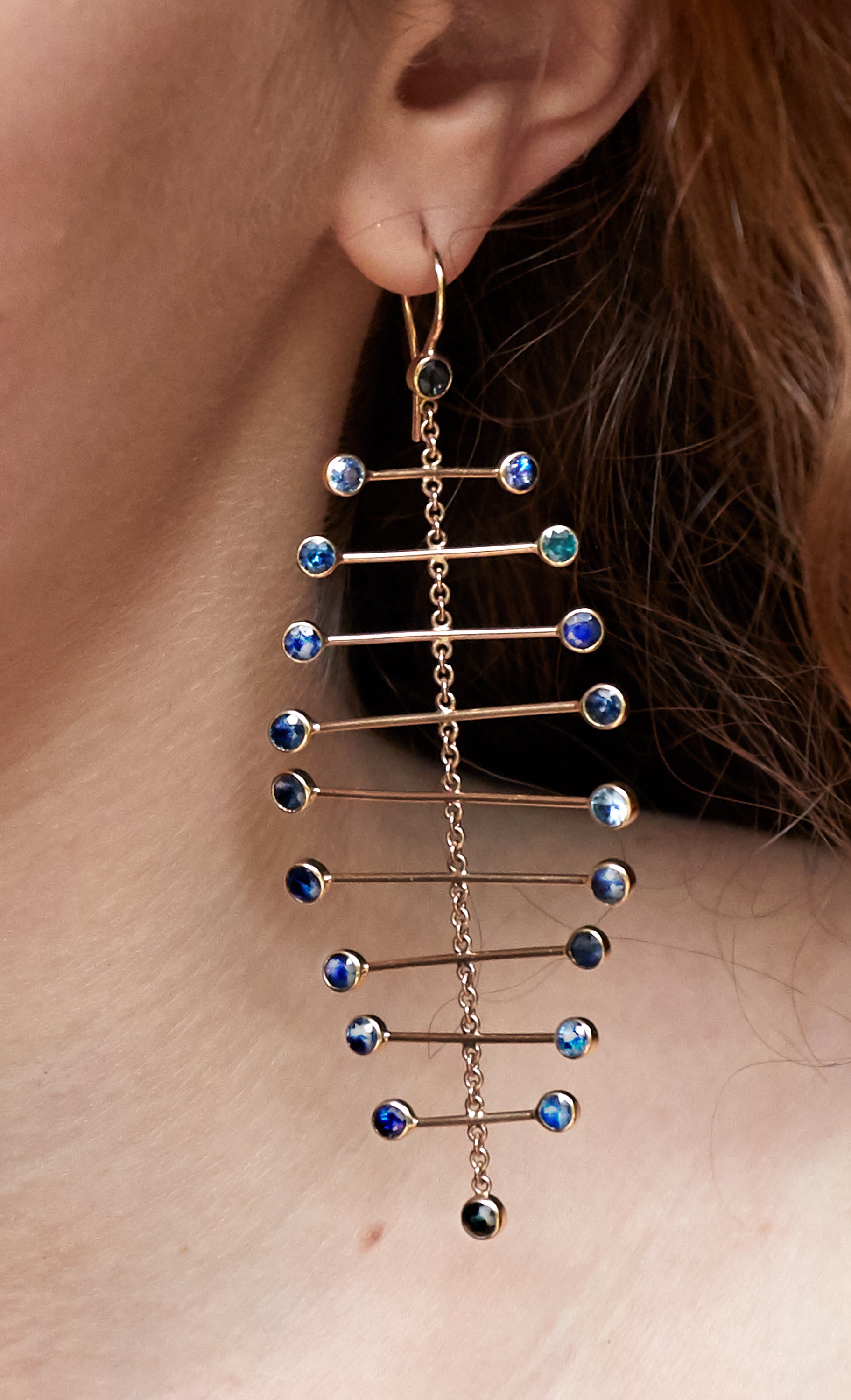 Chorthip Arisa Azure Mobile Earrings featuring blue sapphire gemstones set in gold with elegant, dangling design.