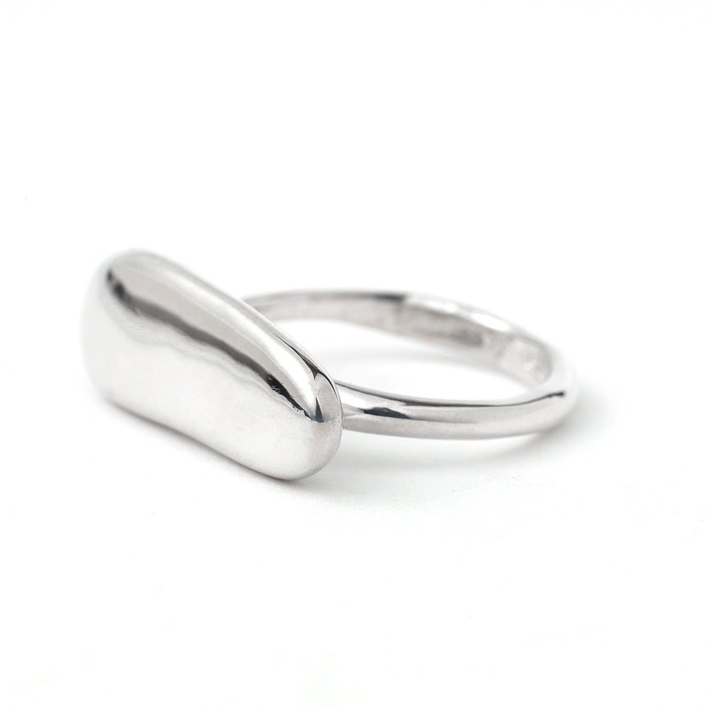 Silver elongated pebble ring by Chorthip featuring smooth, rounded stone-like design and a sleek, modern band style.