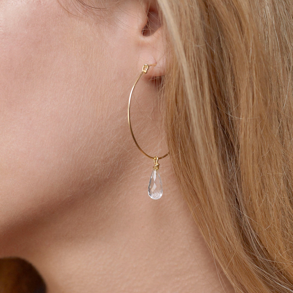 Round knot hoop earrings by Chorthip with white topaz stones, showcasing a stylish and elegant jewelry design.