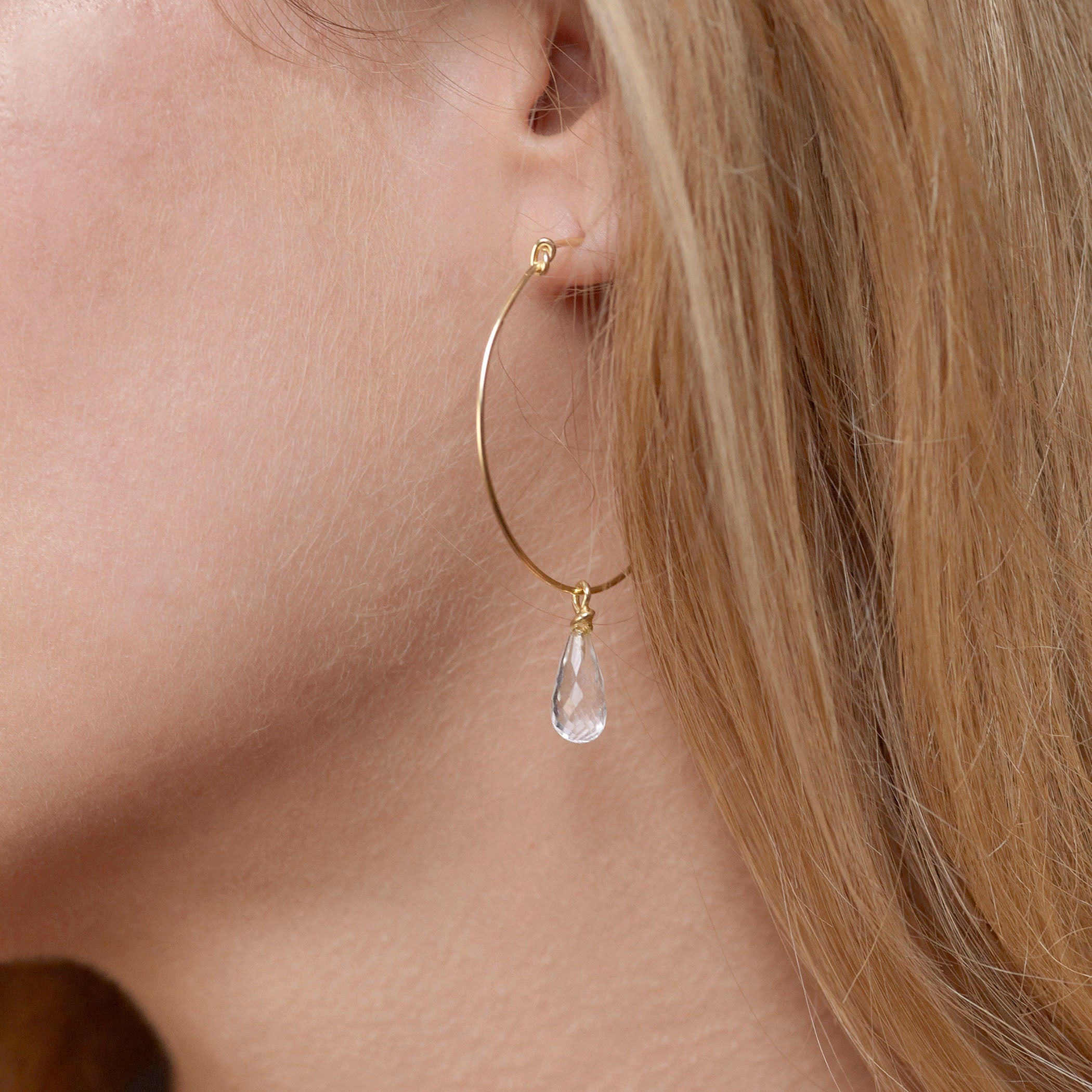 Round knot hoop earrings by Chorthip with white topaz stones, showcasing a stylish and elegant jewelry design.