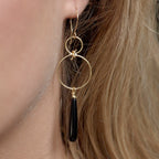 Chorthip infinity knot earrings with black onyx drops, elegant jewelry featuring a sleek knot design and dangling onyx stones.