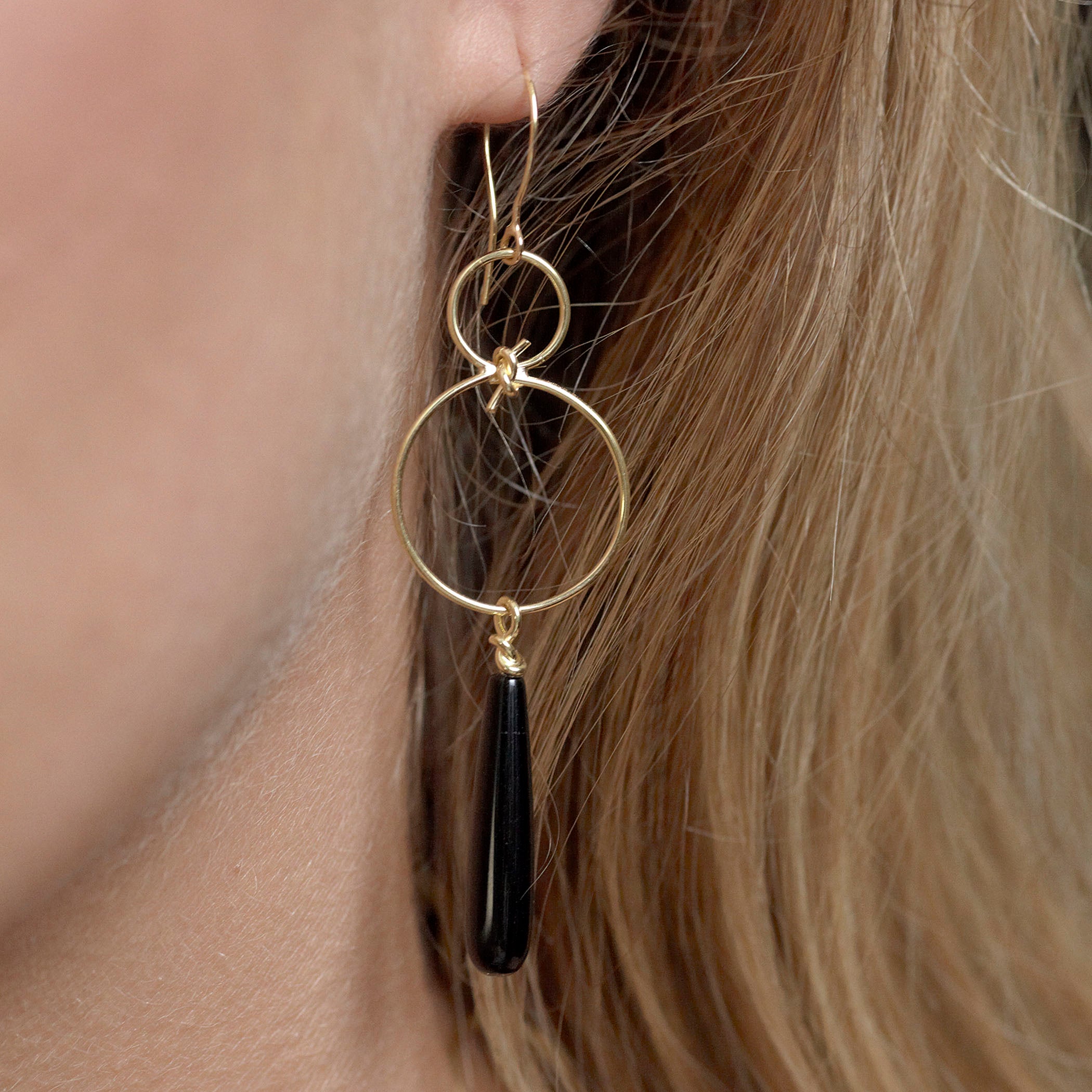 Chorthip infinity knot earrings with black onyx drops, elegant jewelry featuring a sleek knot design and dangling onyx stones.