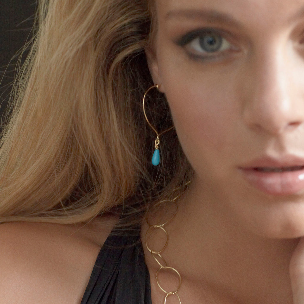 Chorthip Lotus Knot Hoop Earrings with Sleeping Beauty Turquoise Drop, featuring intricate silver design and vibrant turquoise stone.