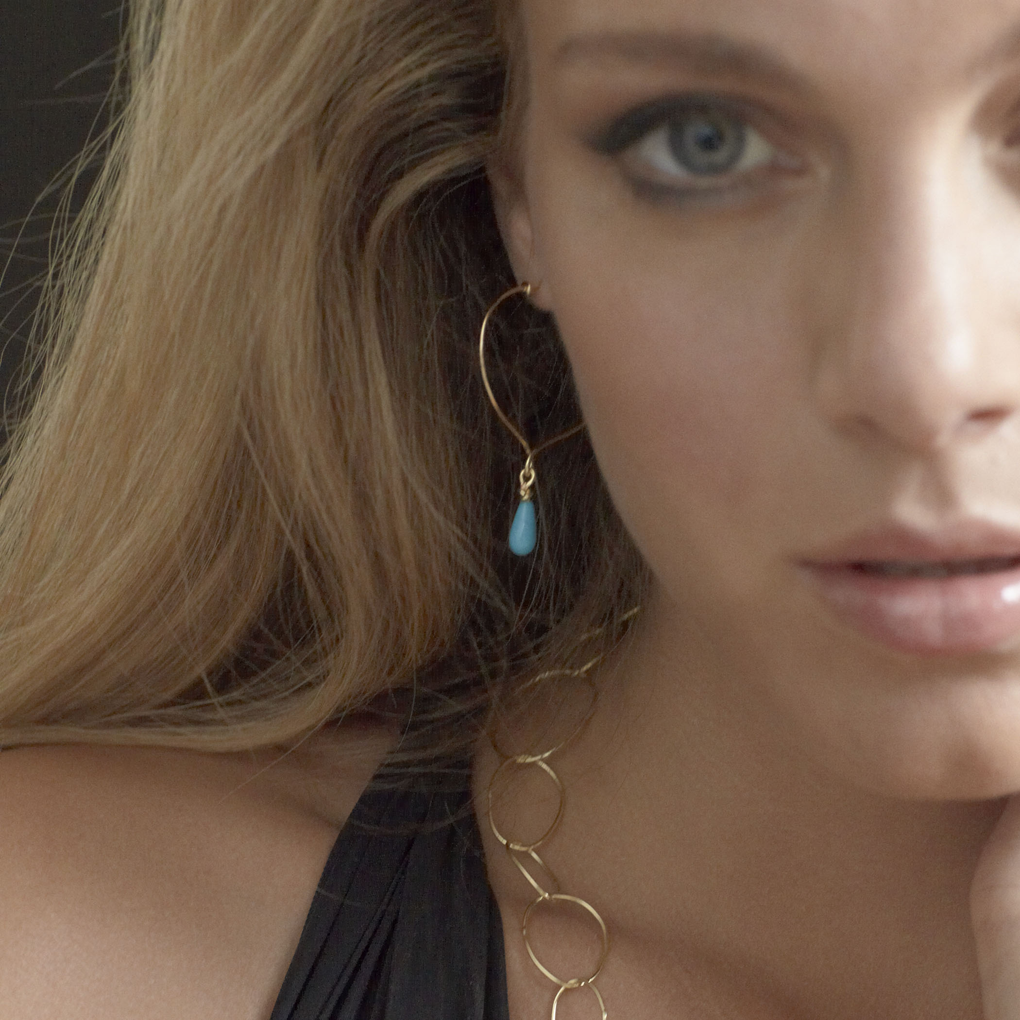 Chorthip Lotus Knot Hoop Earrings with Sleeping Beauty Turquoise Drop, featuring intricate silver design and vibrant turquoise stone.
