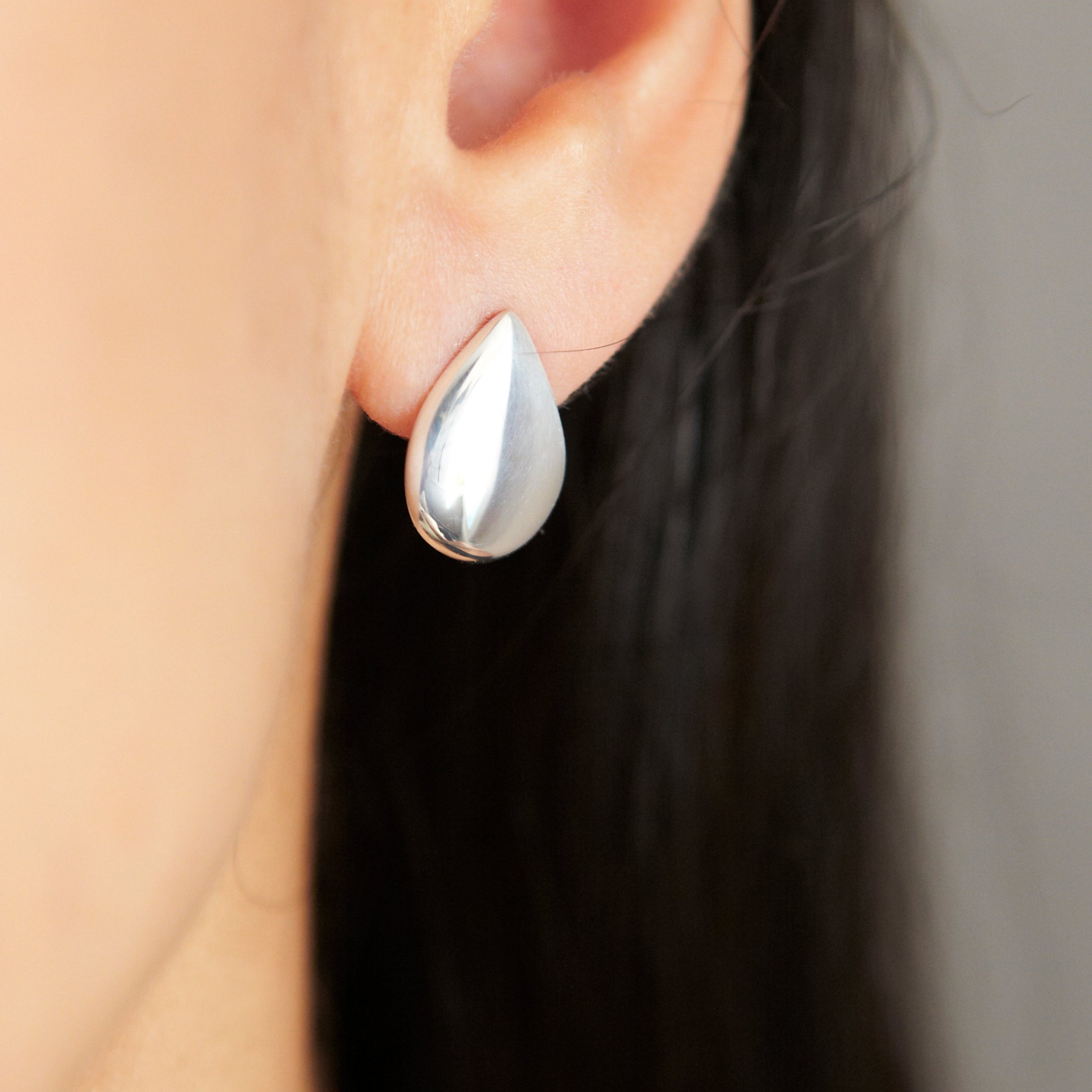 Large button-style raindrop earrings by Chorthip featuring shiny, teardrop-shaped design perfect for stylish accessories.