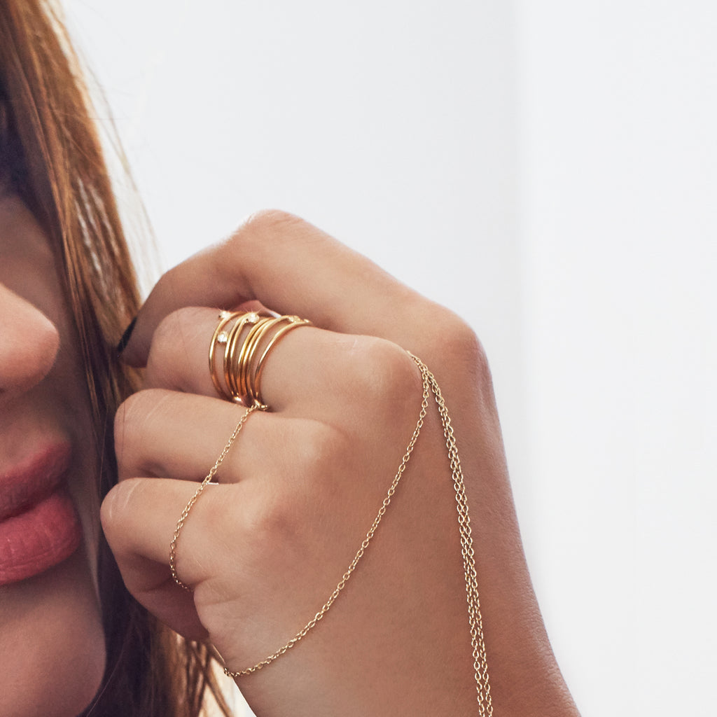 Close-up of Chorthip Helix Stacked Ring Set showing multiple silver rings with textured and smooth finishes on a jewelry display.
