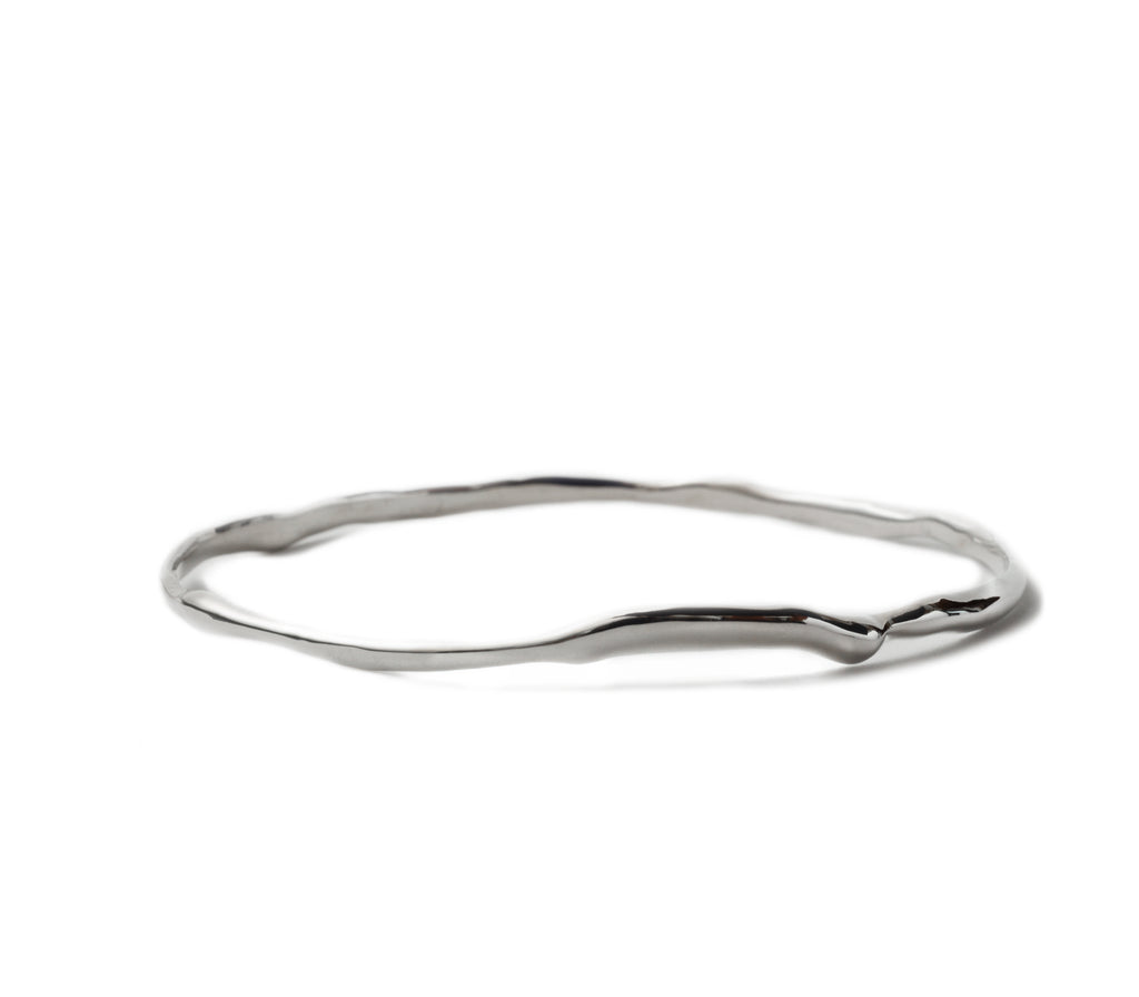 Silver Raindrop Bangle by Chorthip featuring a sleek, curved design with shiny raindrop-shaped accents on a smooth band.