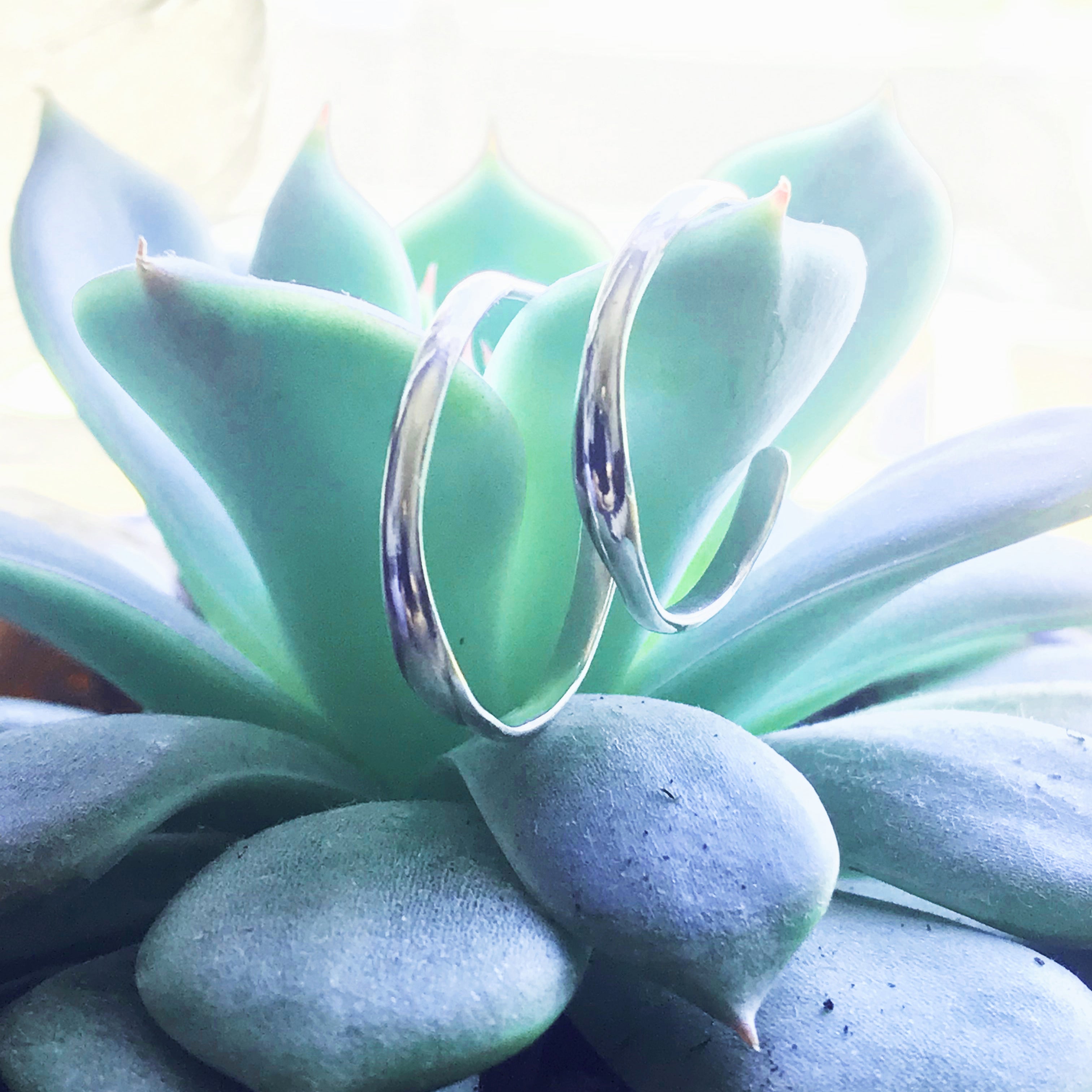 Small raindrop hoop earrings by Chorthip featuring delicate, shiny metal hoops with a smooth raindrop design.
