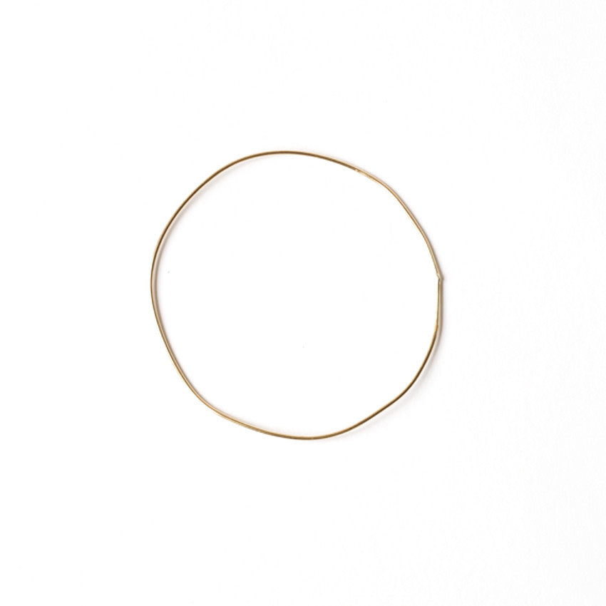 Single URS Gold Bangle by Chorthip featuring a smooth, polished gold wave design on a sleek jewelry bangle.
